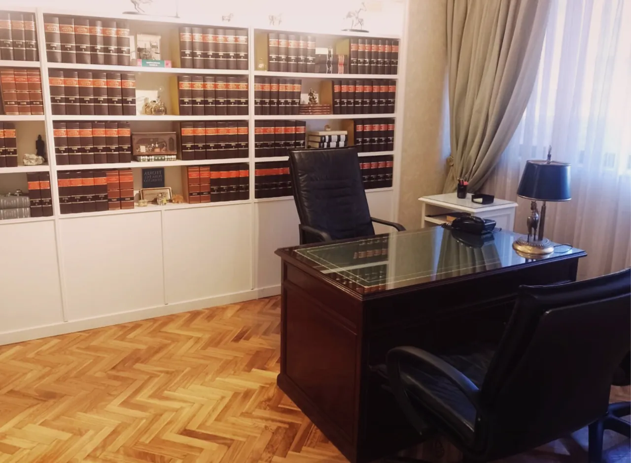 Despacho del estudio, con escritorio y biblioteca jurídica